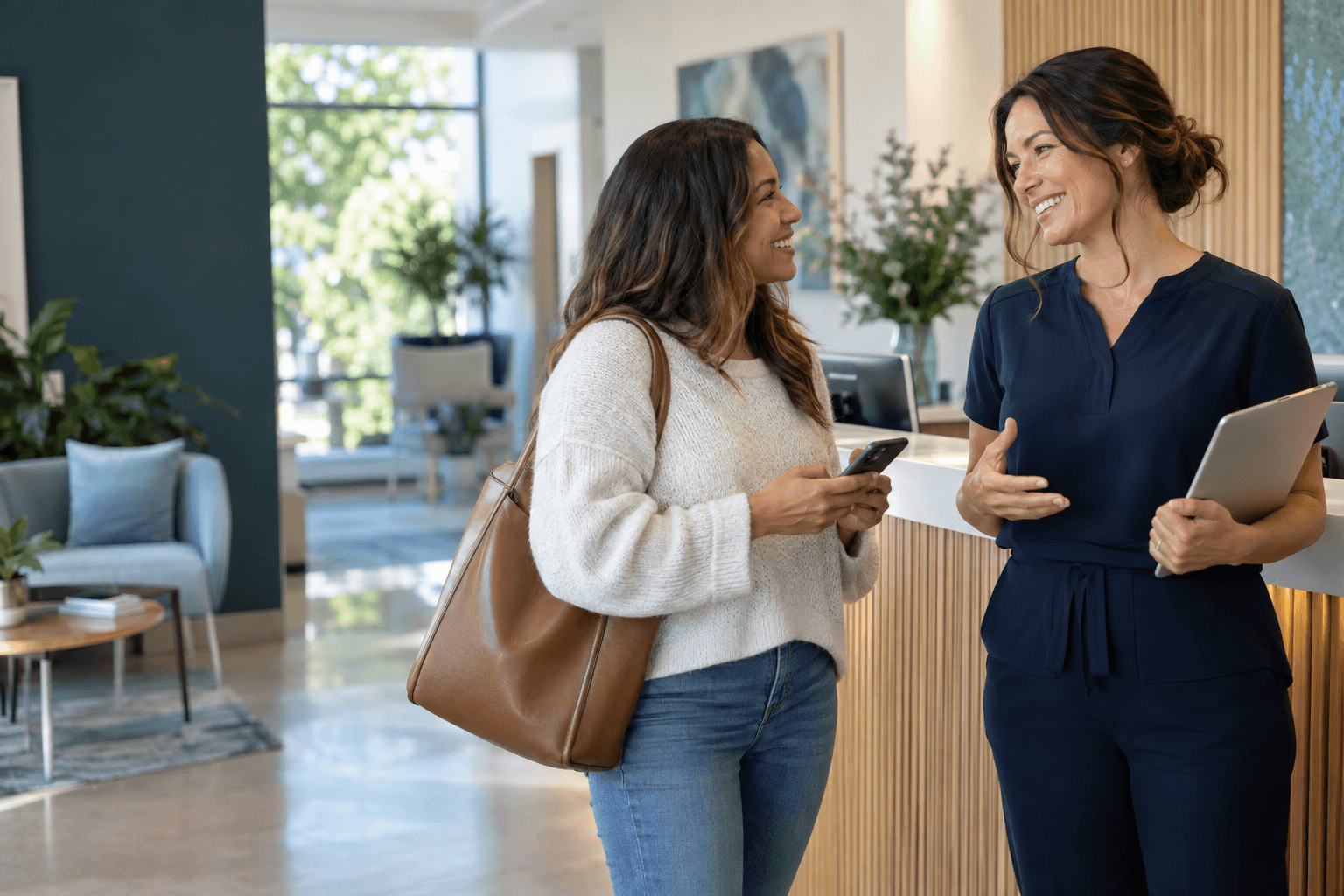 A patient and practice team member sharing a warm conversation at reception